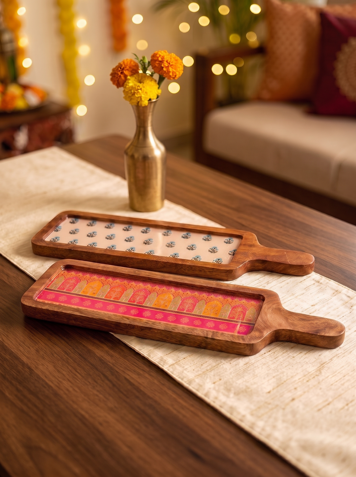 Wooden serving board with handle and blue floral printed inlay, front view in a festive setting