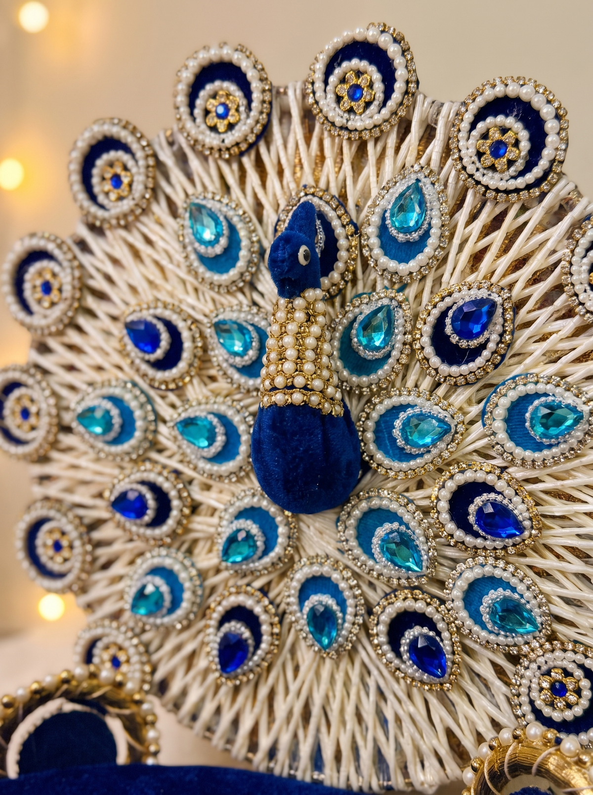 Close-up detail of pearl peacock backrest and gold trim on royal blue velvet singhasan