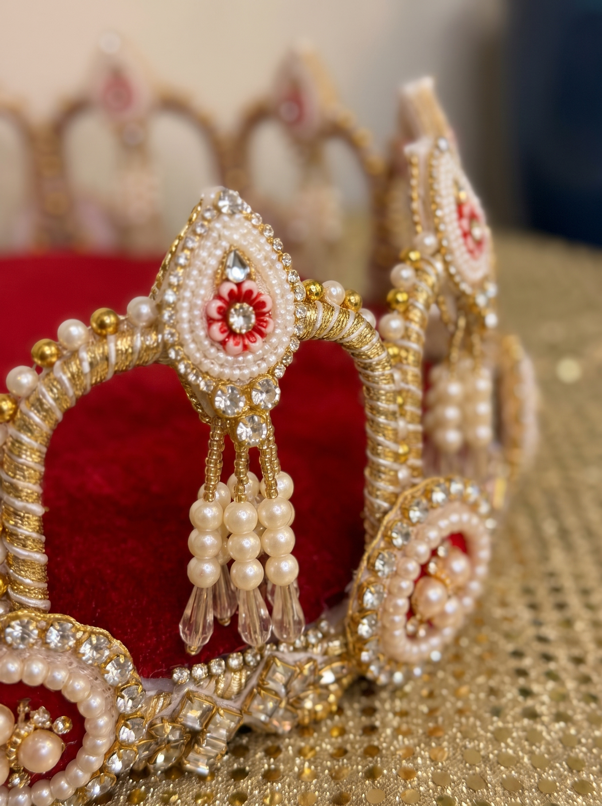 Close-up detail of pearl crown rim on maroon velvet puja thali