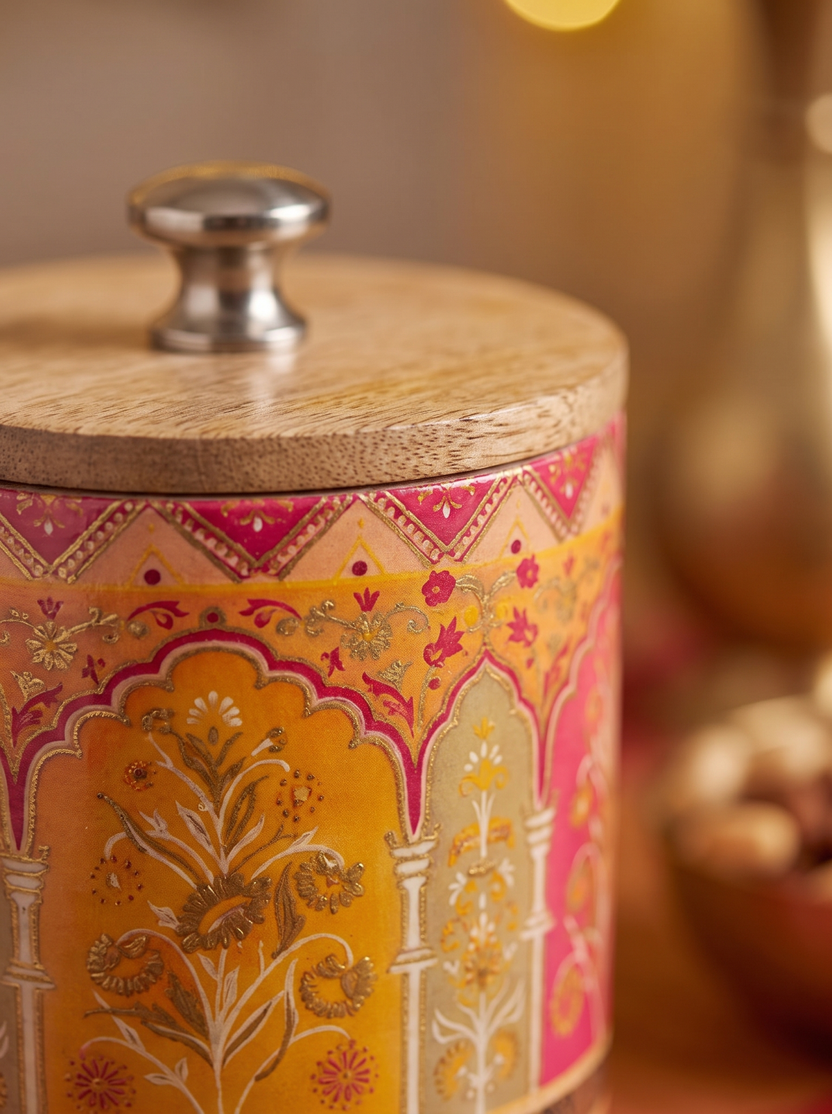 Close-up detail of pink and saffron Mughal arch print on wooden canister jar