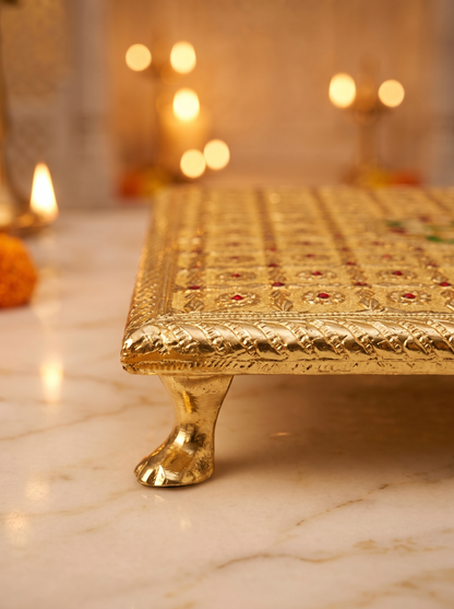 Close-up detail of gold brocade and floral centre on square puja chowki