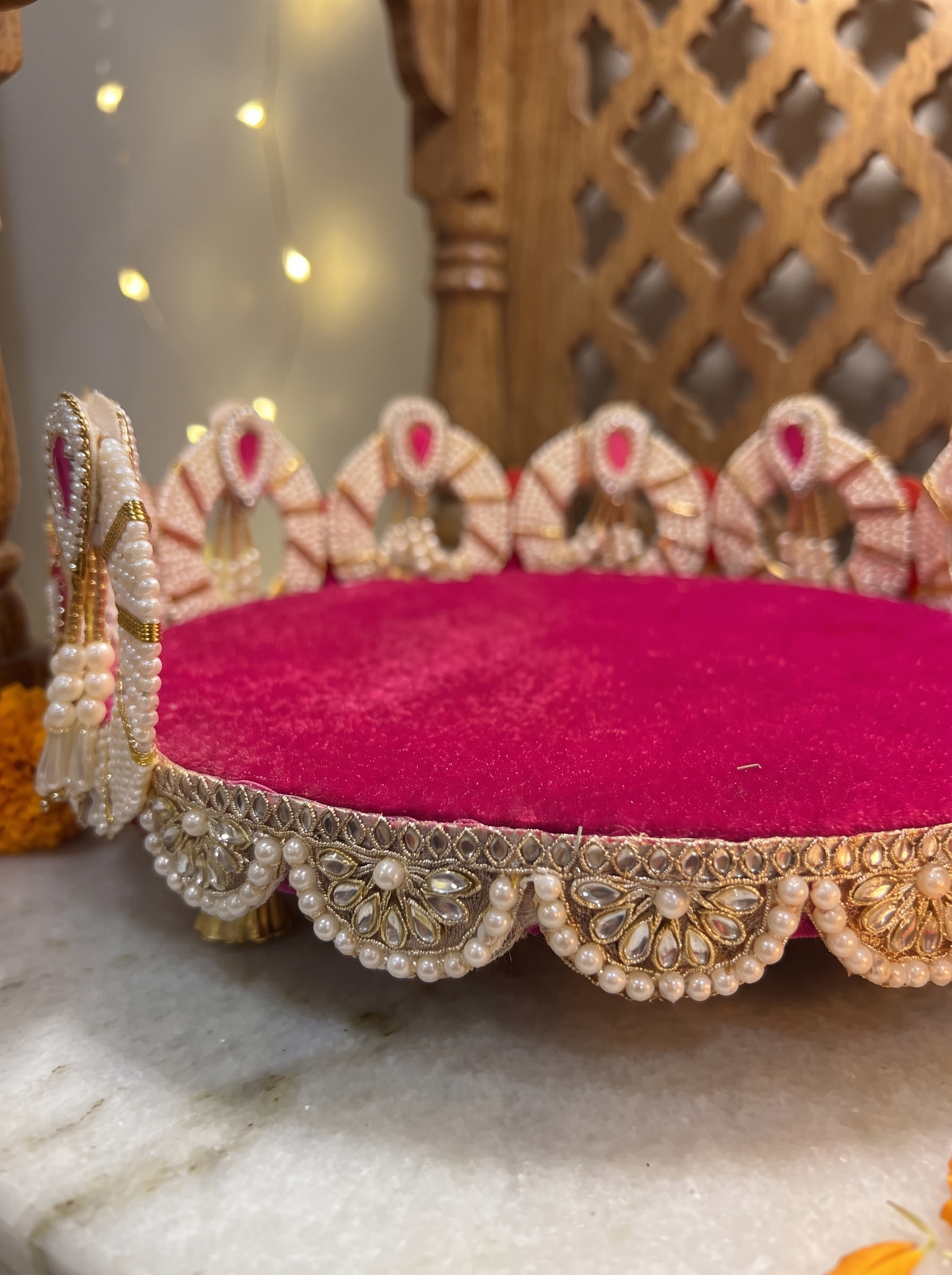 Close-up detail of pearl and kundan scalloped rim on magenta velvet puja thali