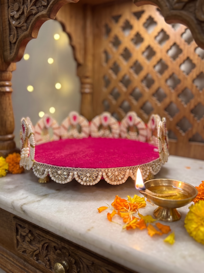Magenta velvet kundan thali for Diwali, angled view with diyas and marigolds