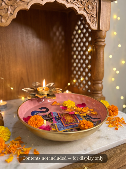 Pink enamel urli styled with floating petals and lit lotus tealight as a Diwali centerpiece