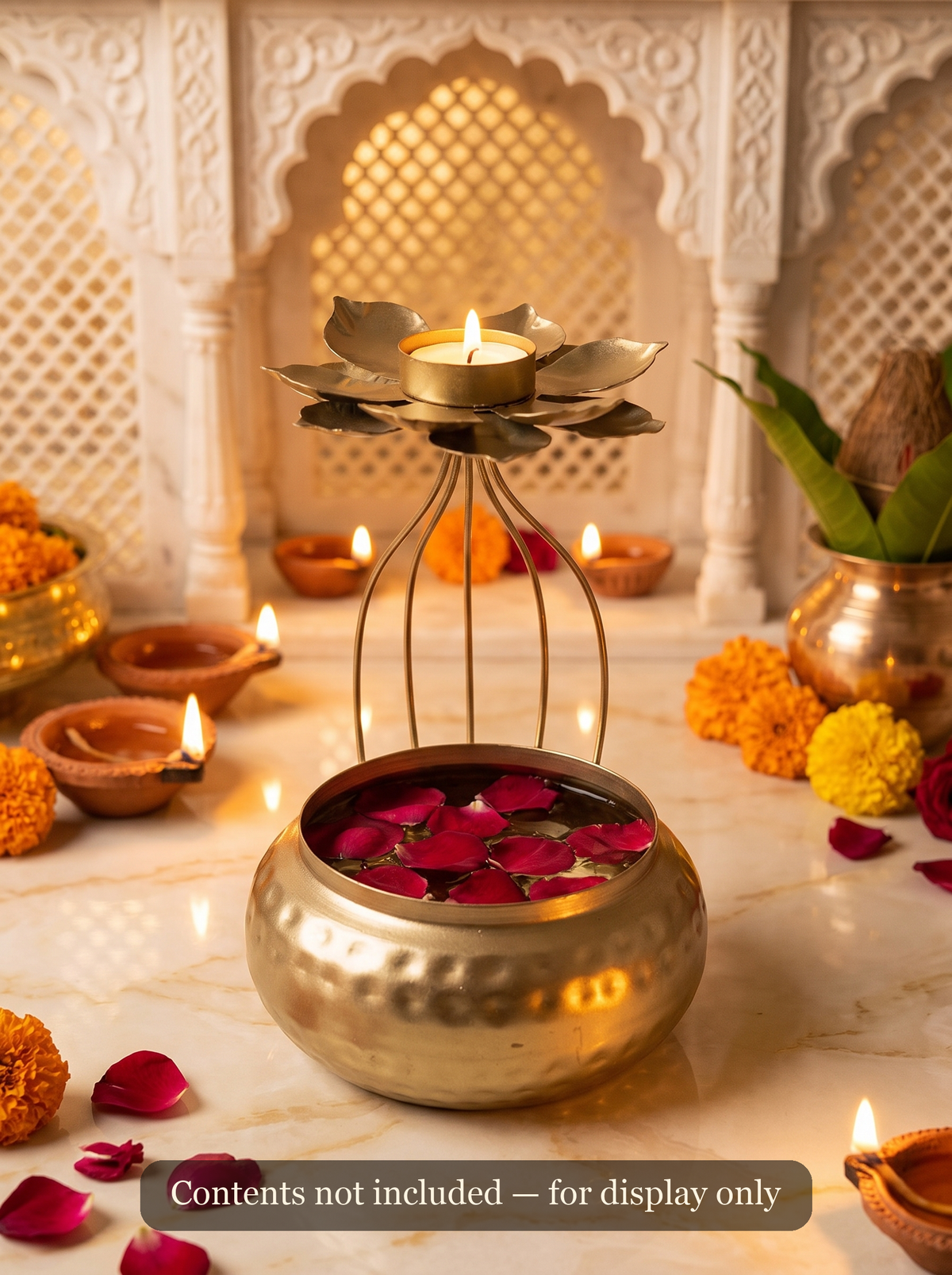 Gold urli pot styled with lit tealights and flowers as a Diwali centerpiece