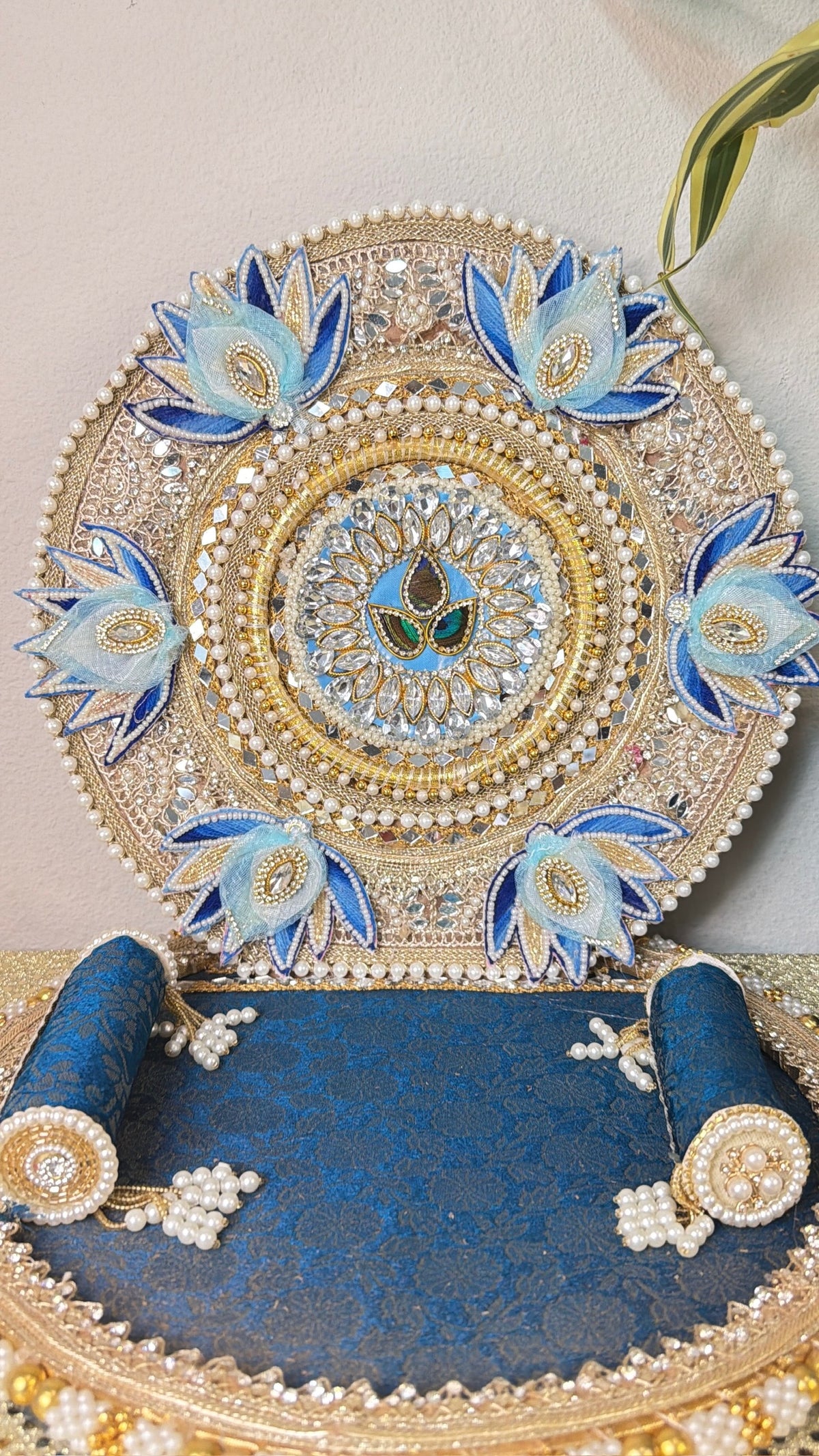Close-up of silver zari embroidery and blue lotus buds on Laddu Gopal singhasan backrest