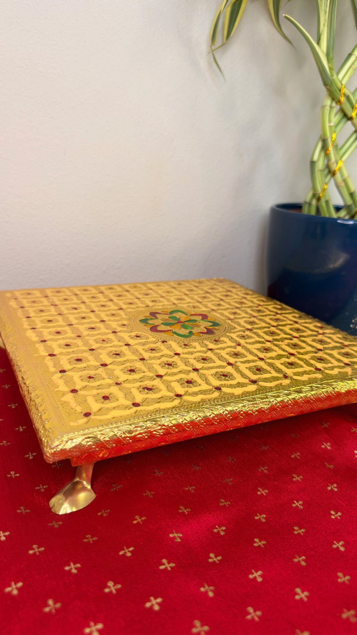 Gold brocade puja chowki showing decorative gold feet