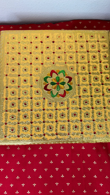Overhead view of gold brocade puja chowki with floral centre medallion