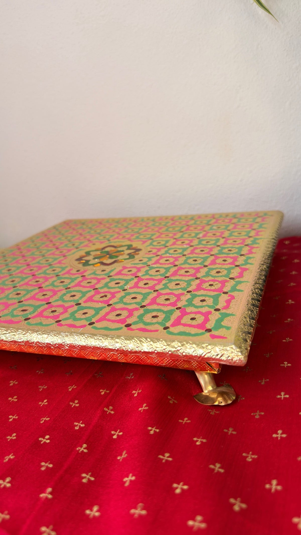 Pink green brocade puja chowki for Ganesh idol, angled view