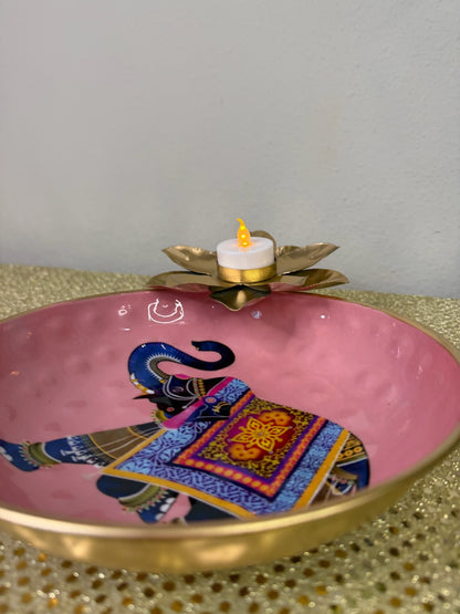 Pink elephant print urli with lit lotus tealight, angled view