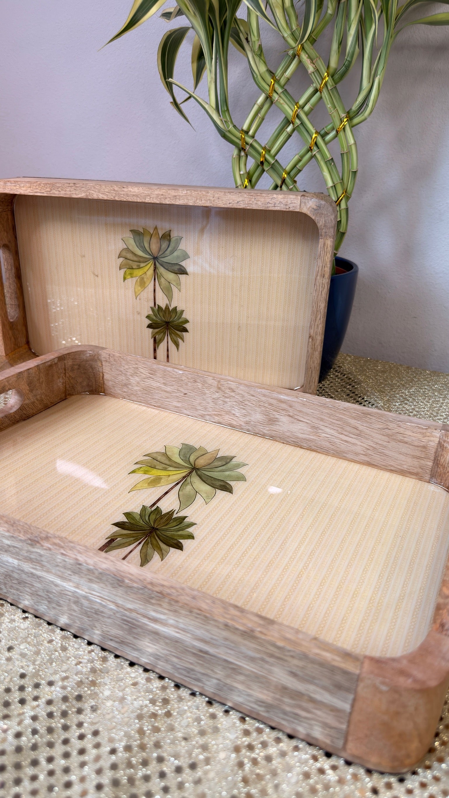 Whitewashed palm print wooden trays styled with plant backdrop