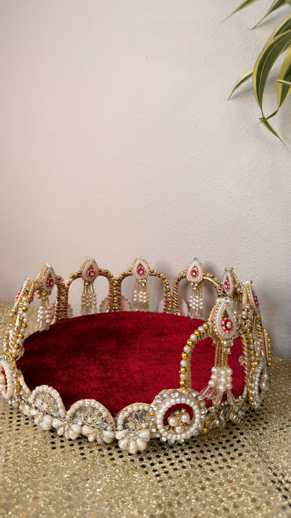 Maroon velvet decorative thali with pearl border, angled view