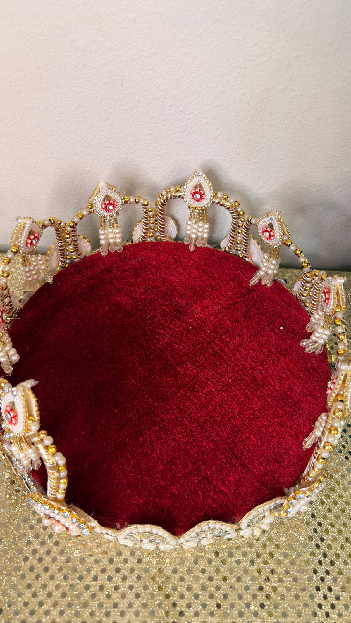 Top view of maroon velvet pooja thali with pearl crown rim