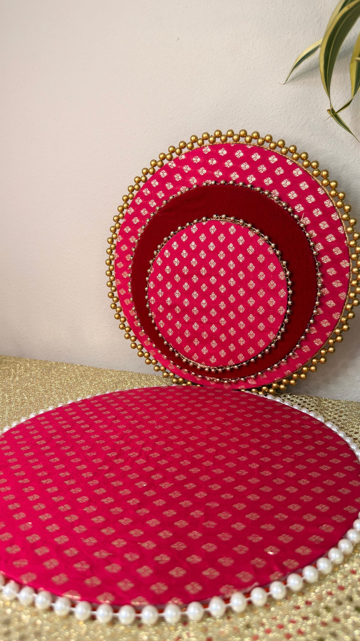Pink brocade puja thali set styled with plant backdrop for Diwali decor