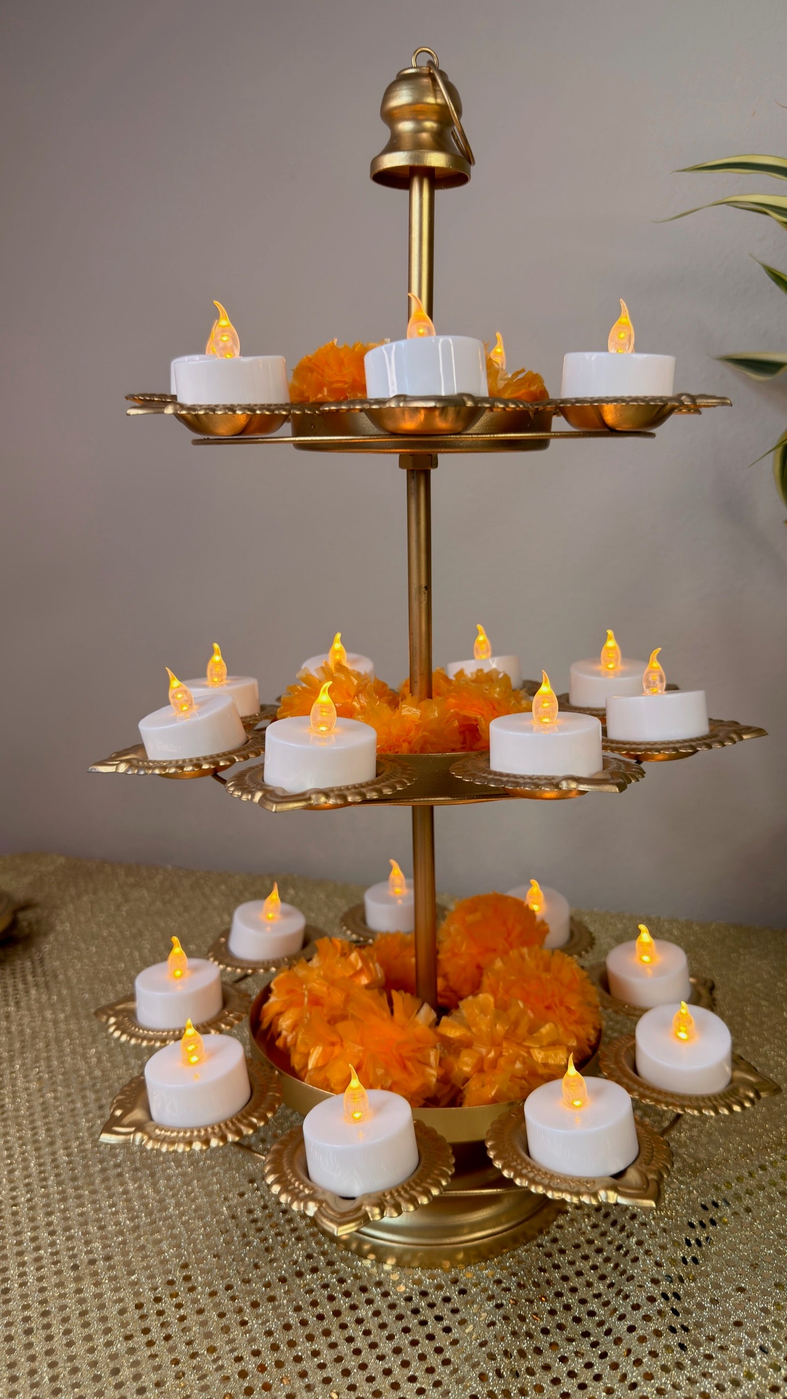 Gold 3-tier lotus diya stand with kalash finial and lit tealights, Diwali tealight tower