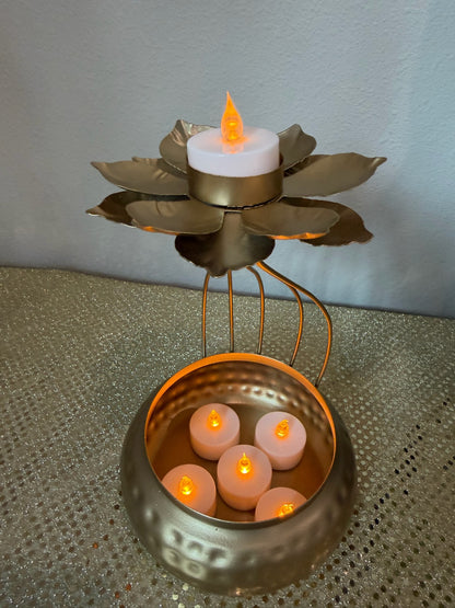 Close-up of lotus tealight cup on gold hammered urli pot