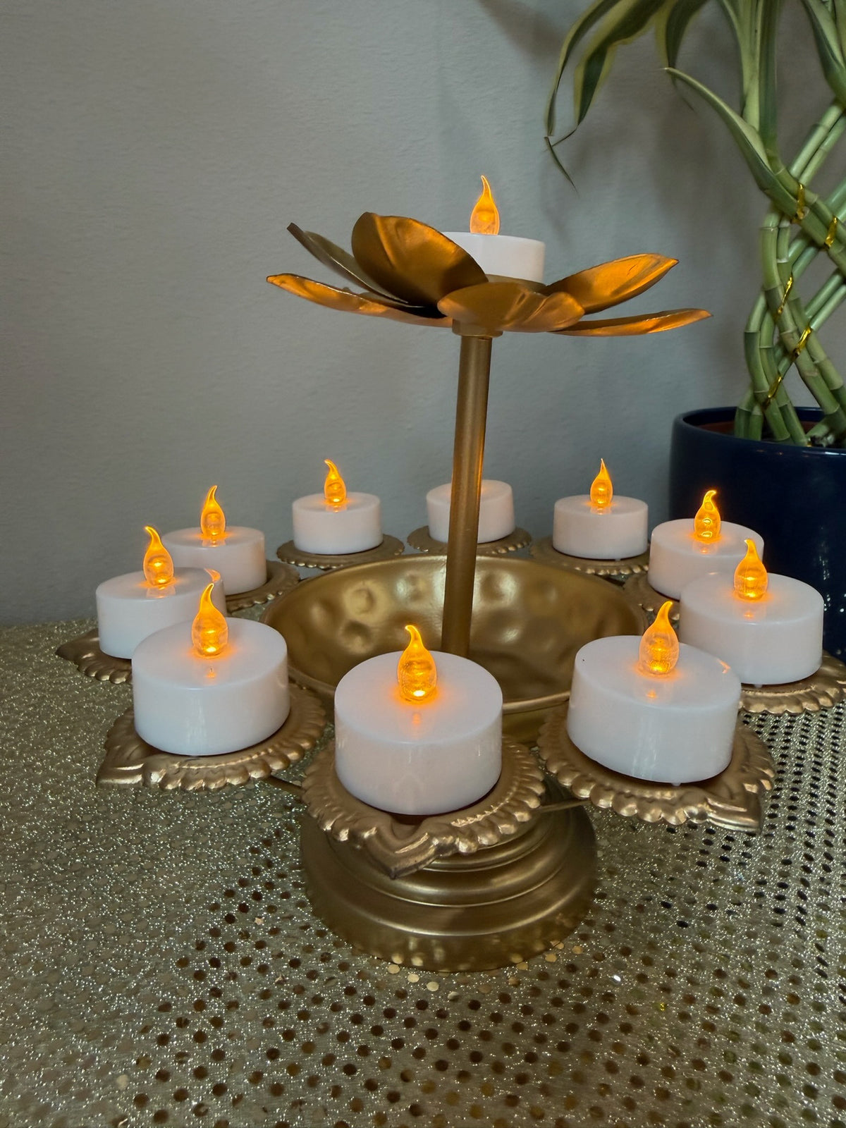 Two-tier gold lotus tealight stand styled with plant backdrop for Diwali decor