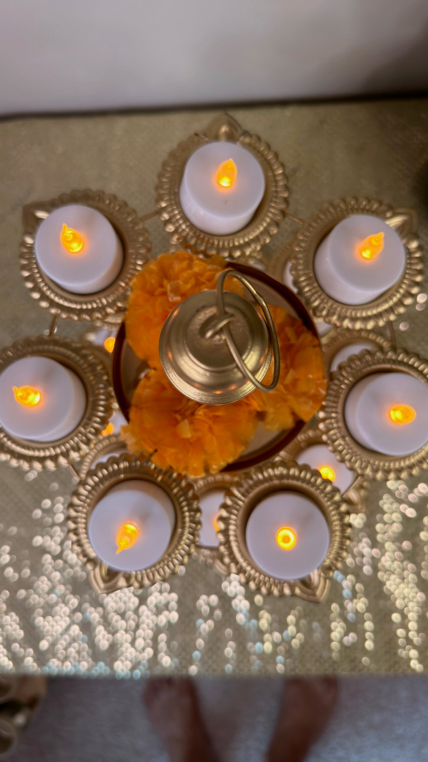 Top view of lotus diya cups on gold 3-tier tealight stand