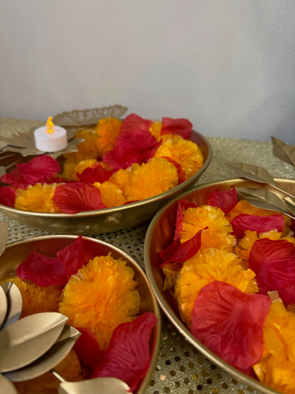 Close-up of gold lotus bowls filled with marigold and rose petals