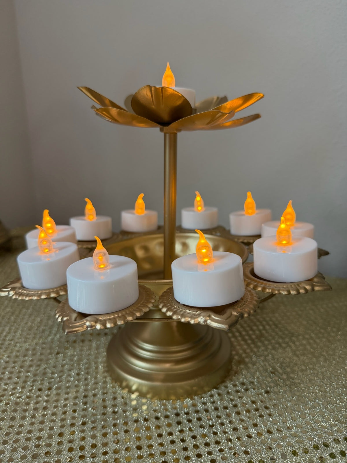 Close-up of lotus finial on gold two-tier tealight stand