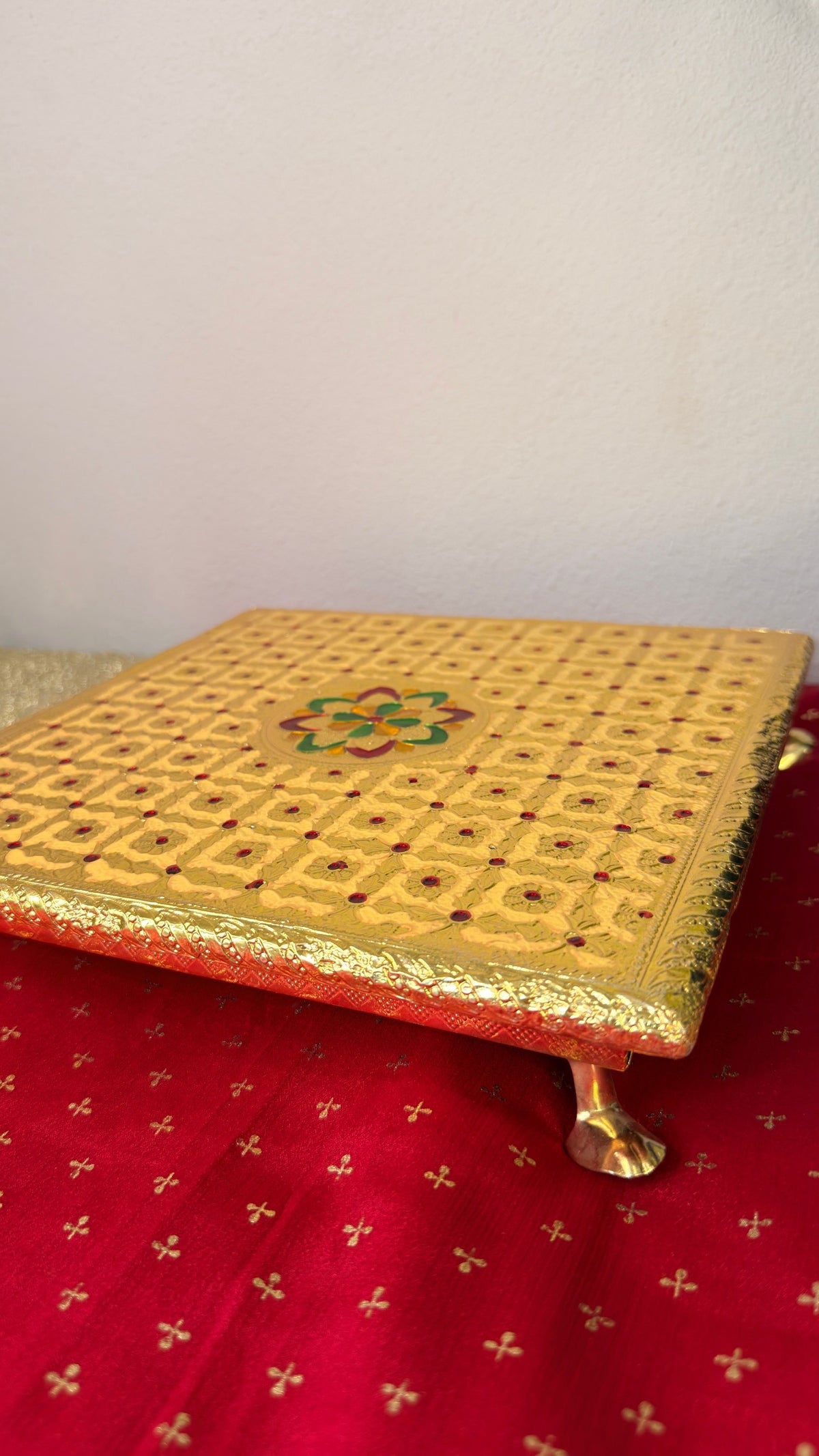 Side detail of gold brocade fabric on square puja chowki